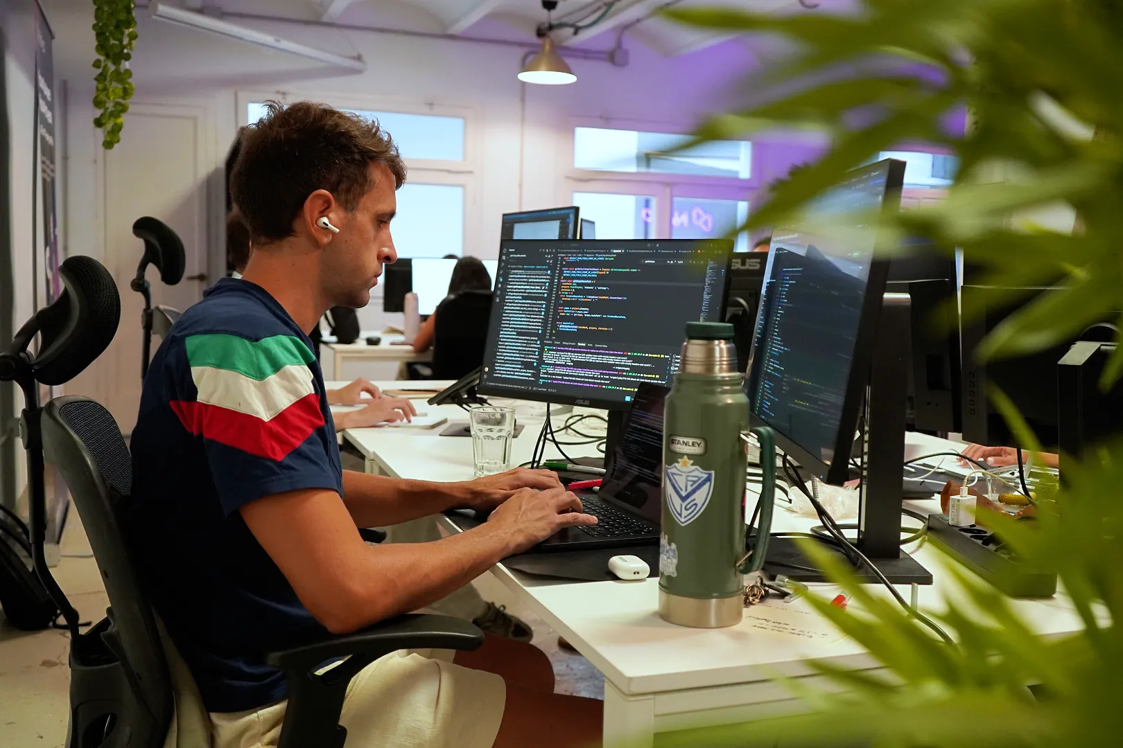 An engineer writing code at a desk in the office