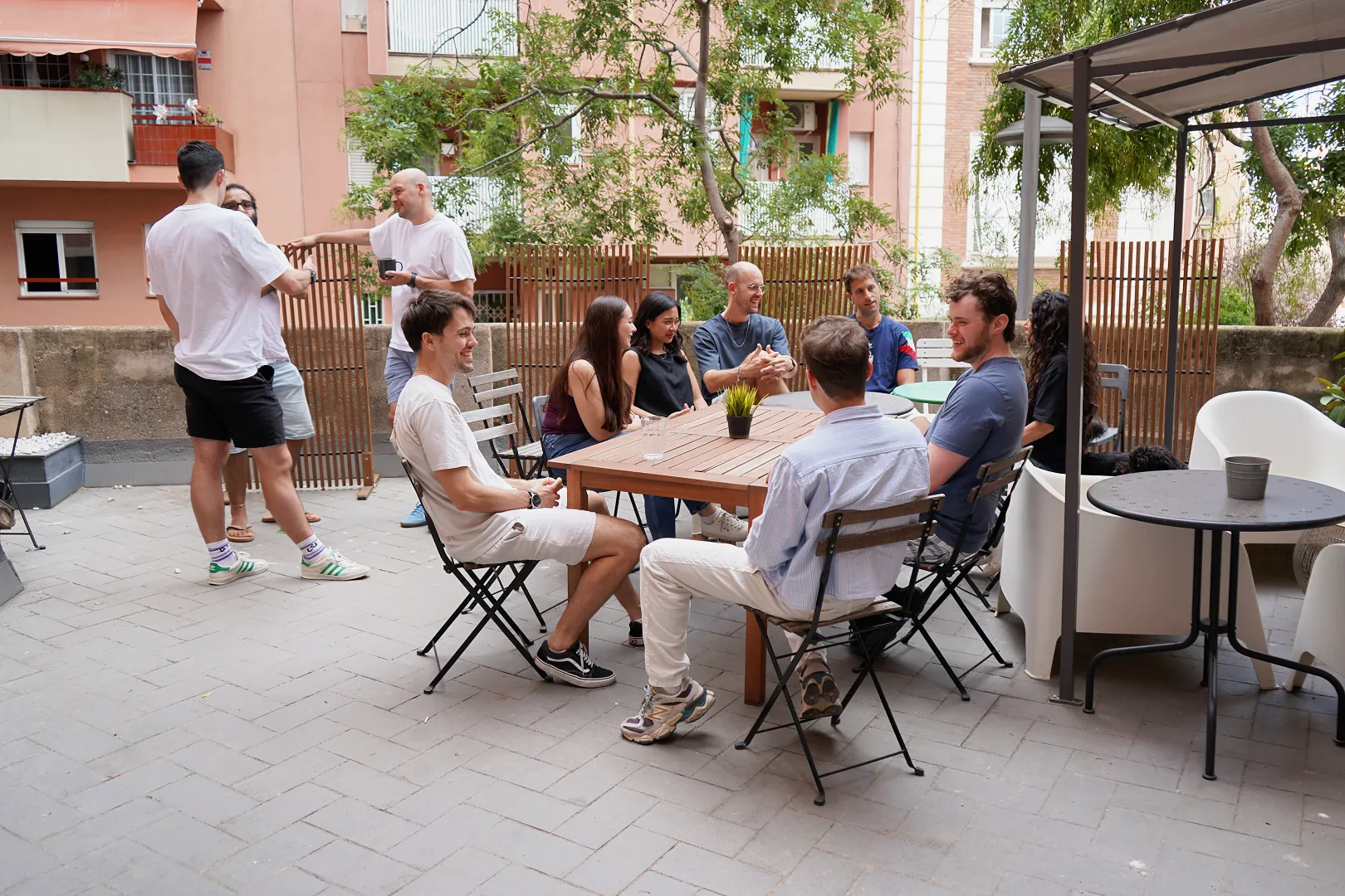 The team chatting around a table on a sunny terrace